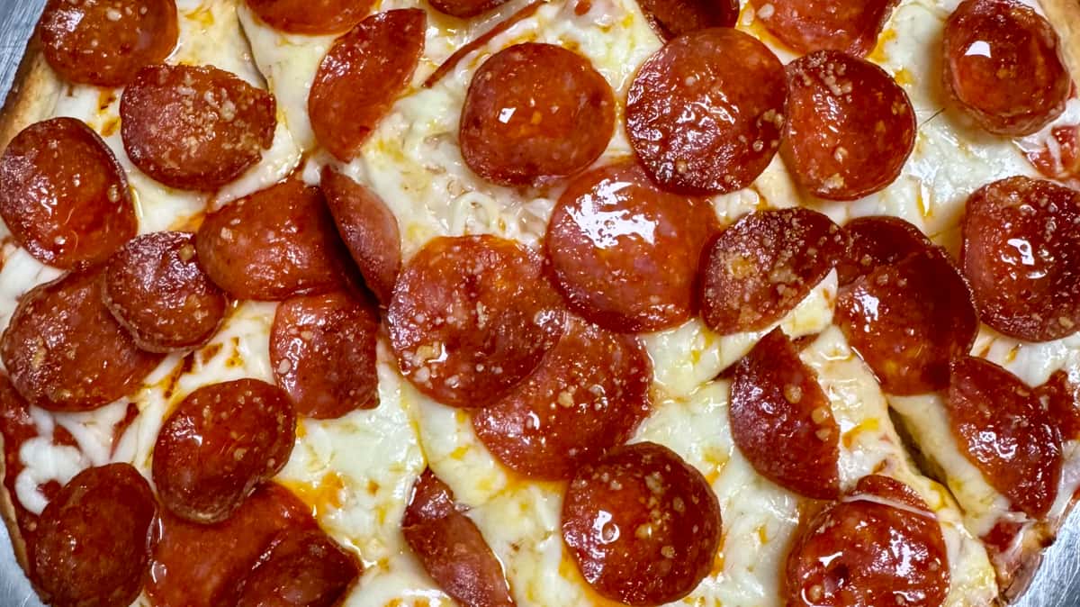 Close up of a pepperoni pizza with melted cheese and crispy pepperoni slices.