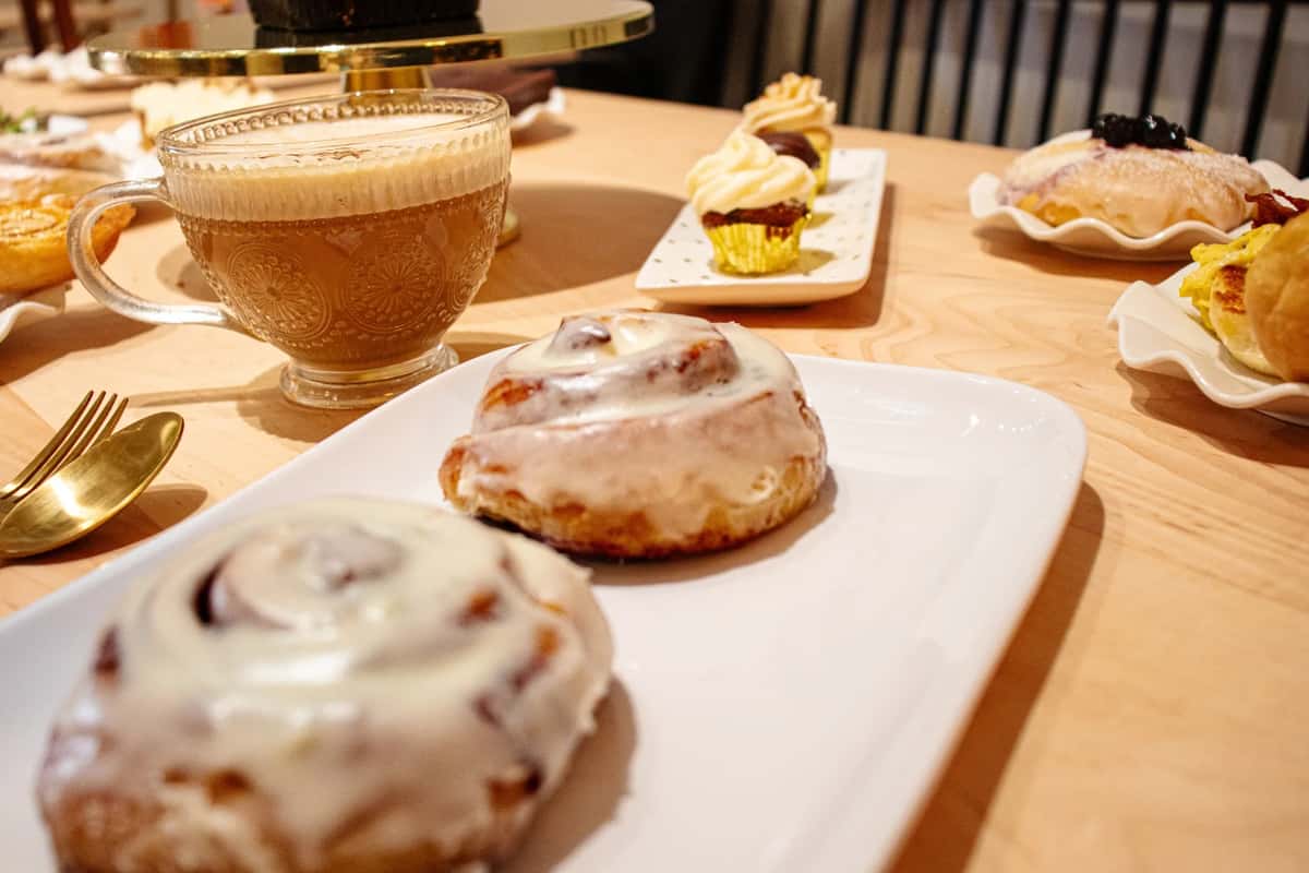 cinnamon rolls, coffee, and cupcakes on wooden table