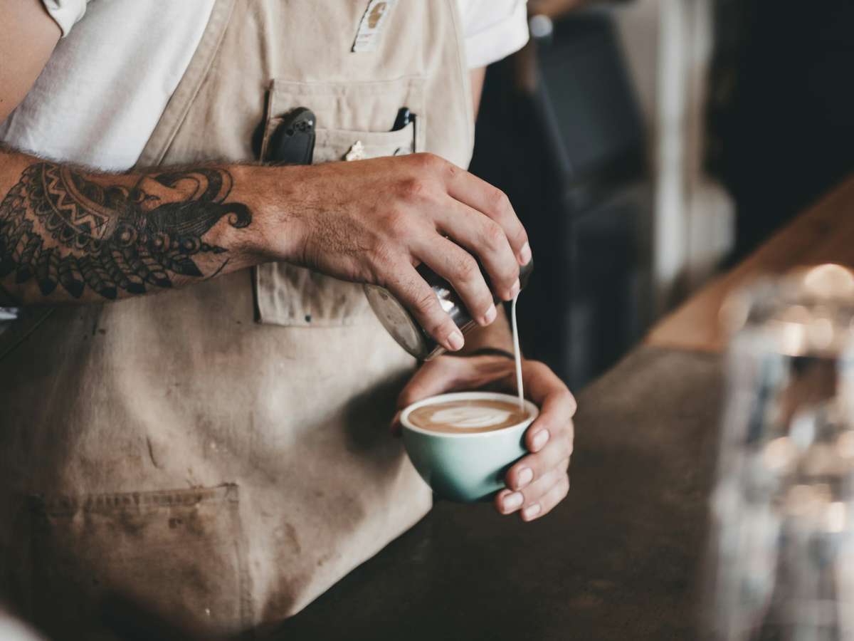 Barista cooking up a delicious drink behind a counter at a cafe