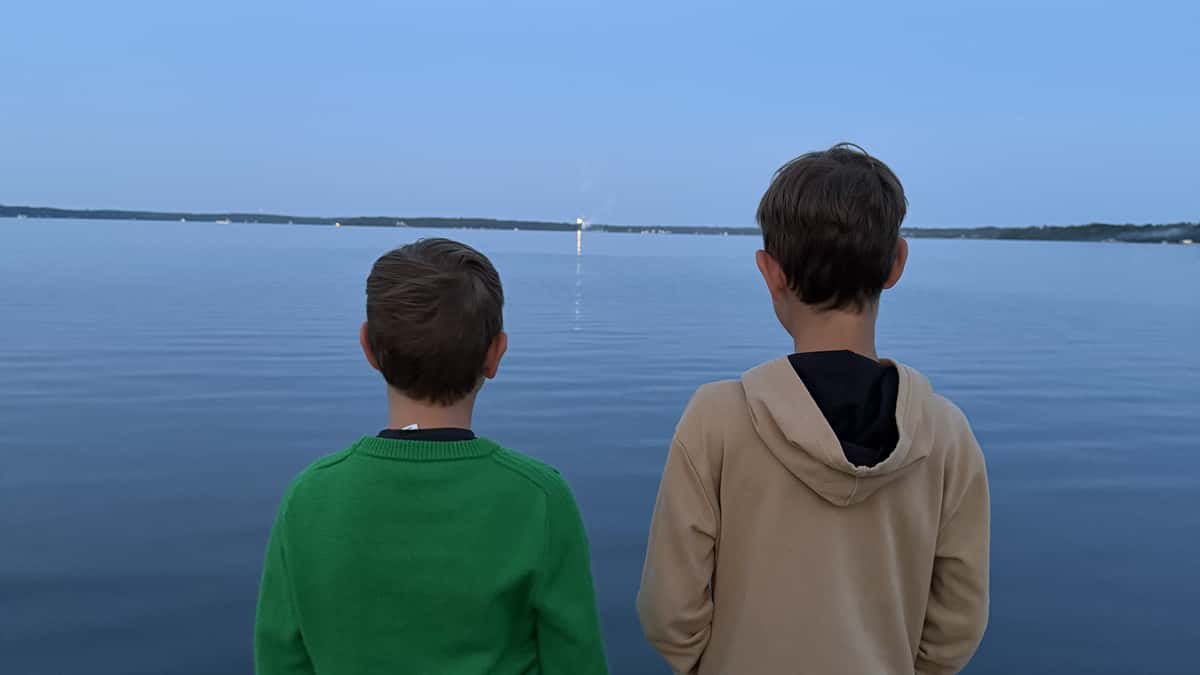 Two boys standing on a pier