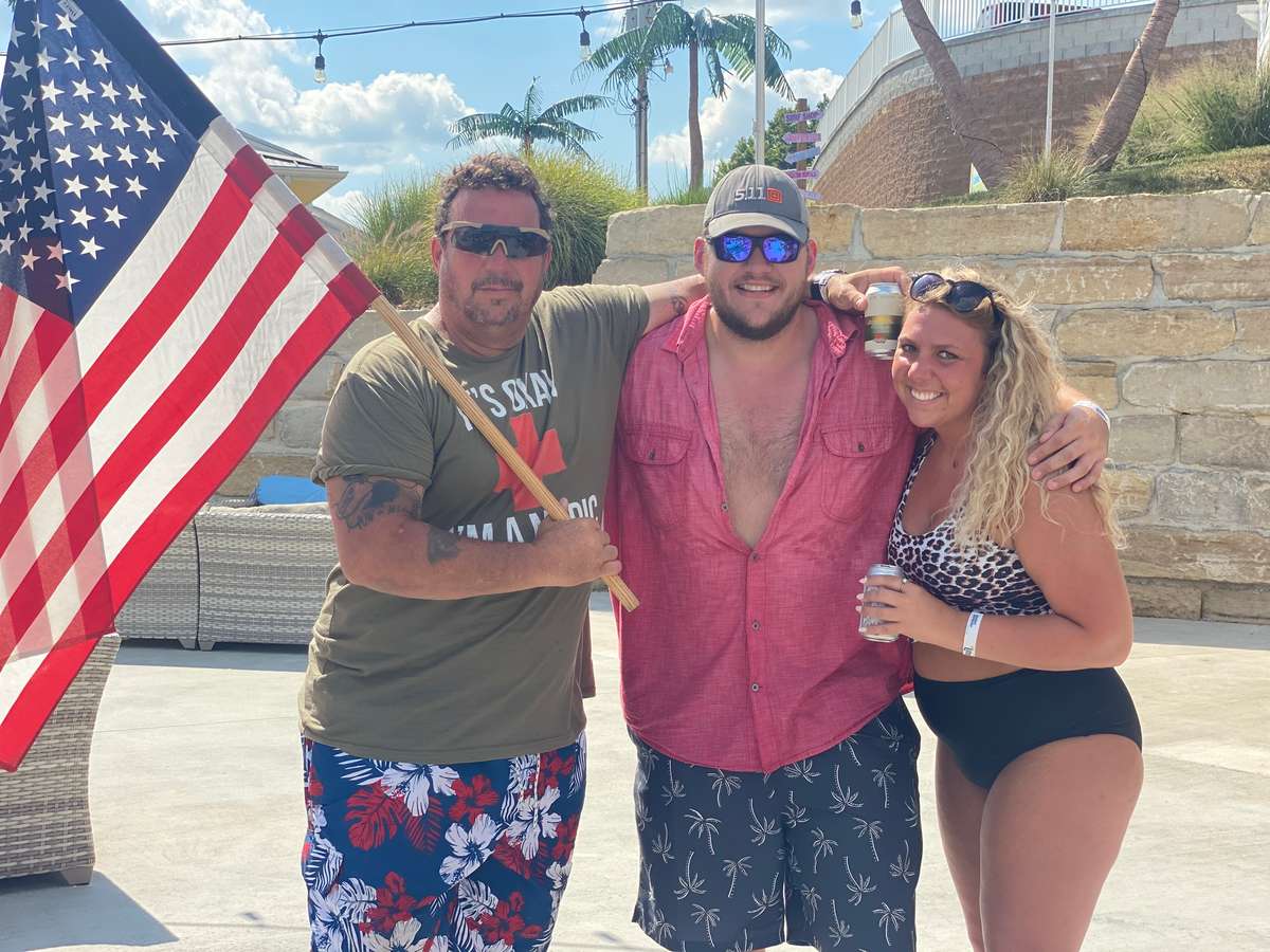 three people holding american flag