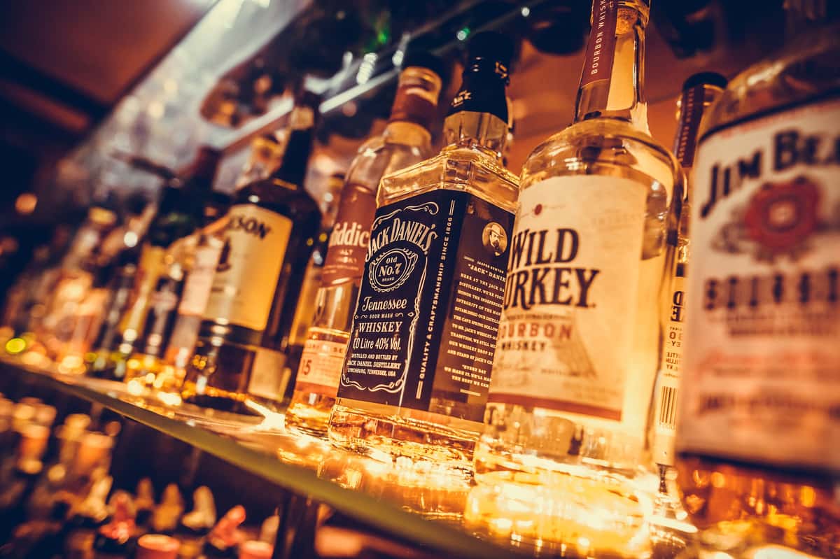 alcohol bottles in a row, displayed in a pub or restaurant