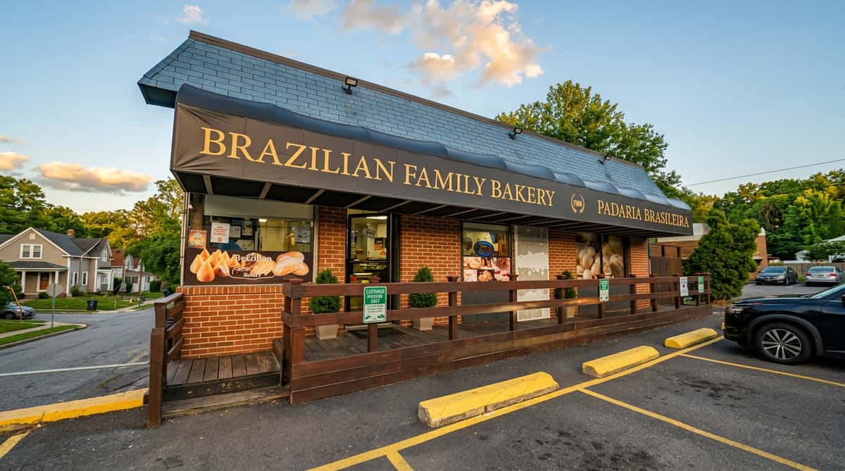 Brazilian Family Bakery storefront with a dark awning, wood railing entrance, and a parked car.