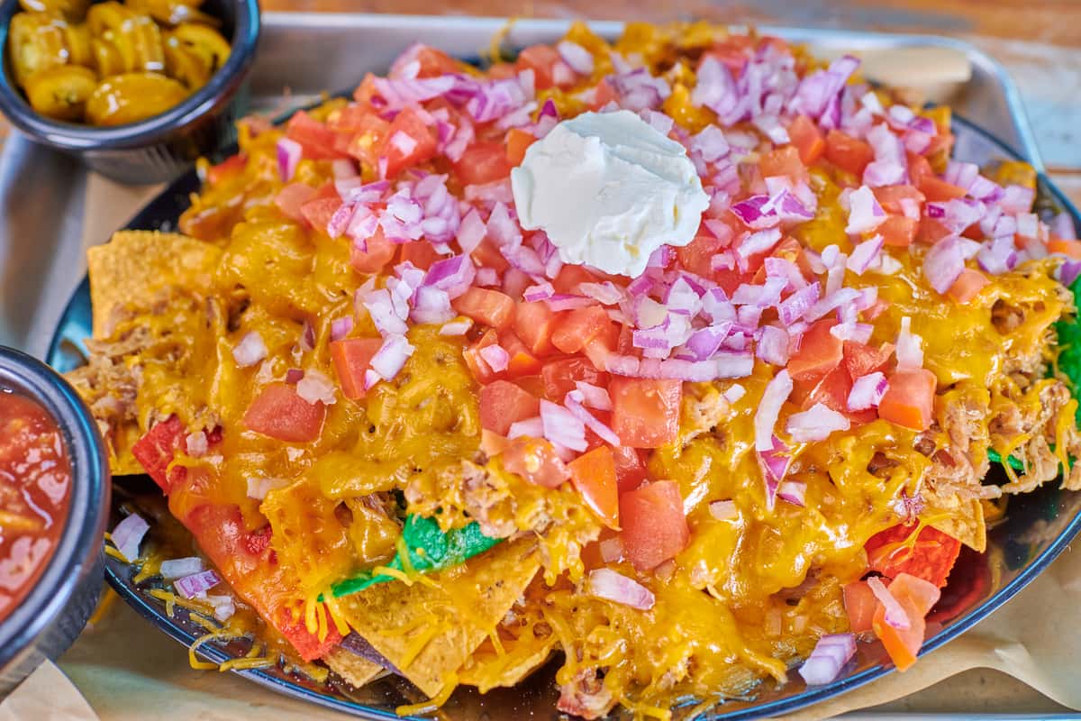 arisov cros loaded with red onion. green onion, and tomato, with pulled pork and cheddar. Served with jalapenos, salsa, and sour cream