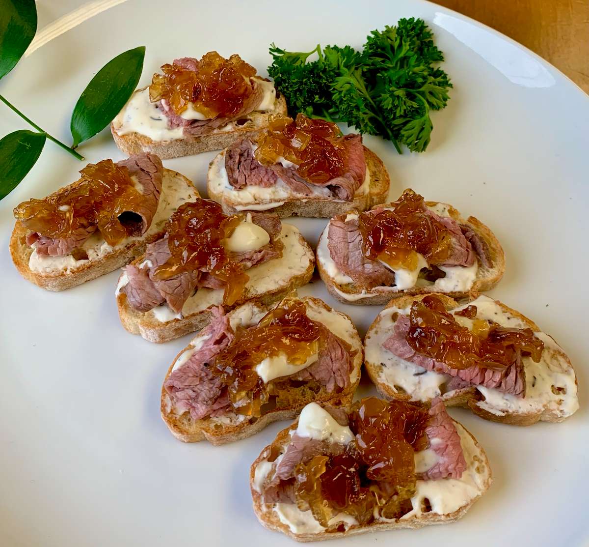 Chilled Tenderloin Crostini appetizers served on a platter