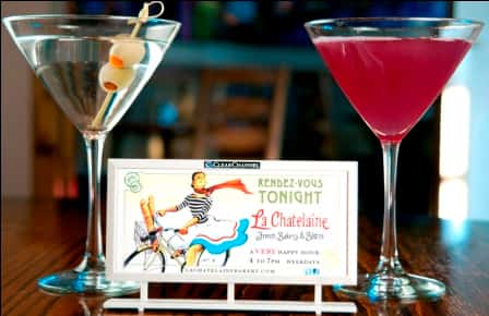 Two martinis on a bar-top with cards for an event 