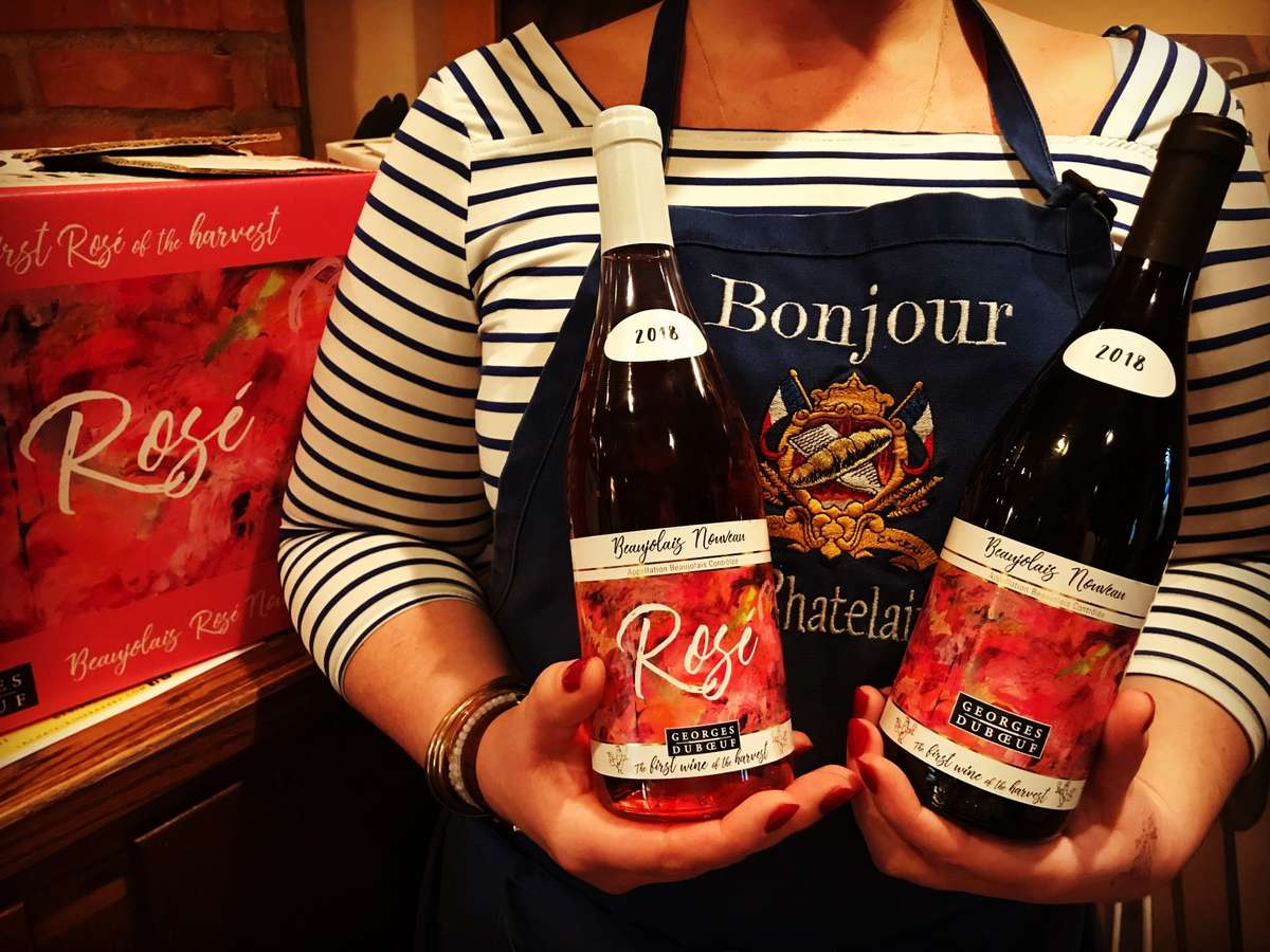 La Chatelaine server holding two bottles of red wine