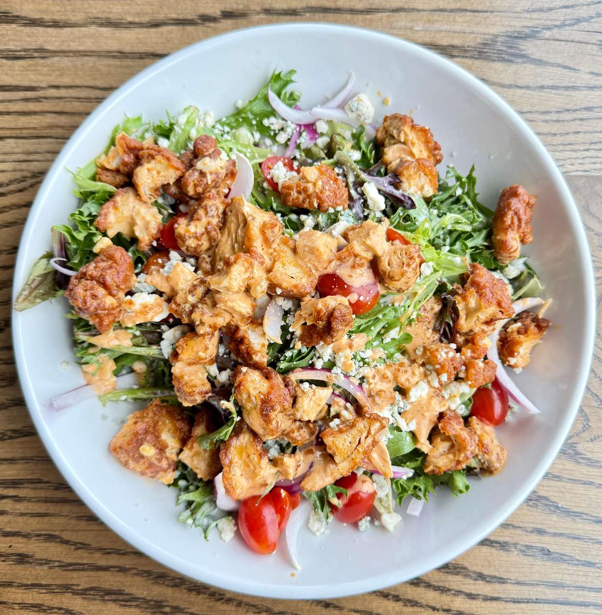 Chopped greens, mixed with Viking sauce coated chicken fingers, ranch dressing, tomatoes, red onions and bleu cheese crumble.