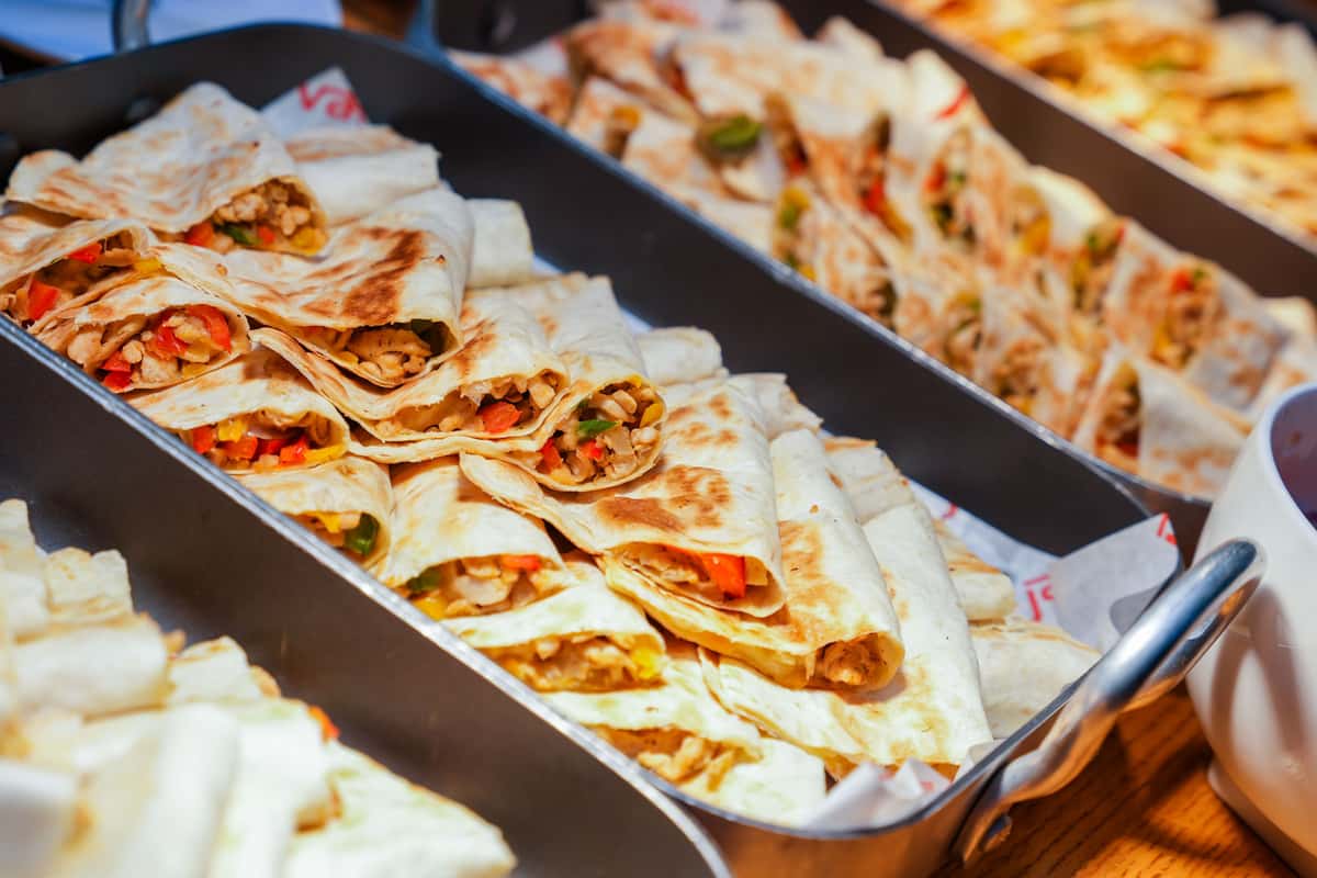 Appetizing quesadillas served in metal trays, filled with vegetables and ready for a meal.