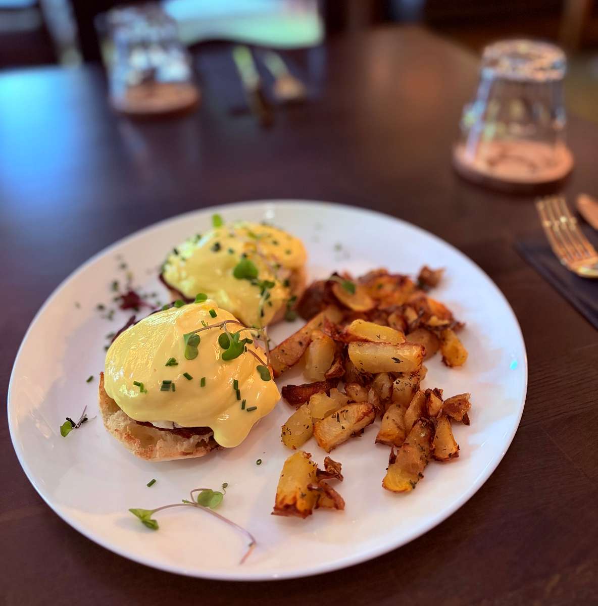 Classic Egg Benedicts with hashbrowns and fresh herbs