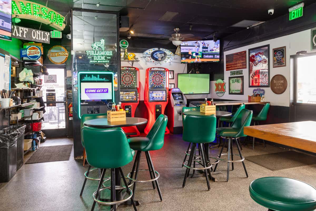 Sports lounge entertainment area with dart machines, TVs, and colorful seating for guests and sports fans.
