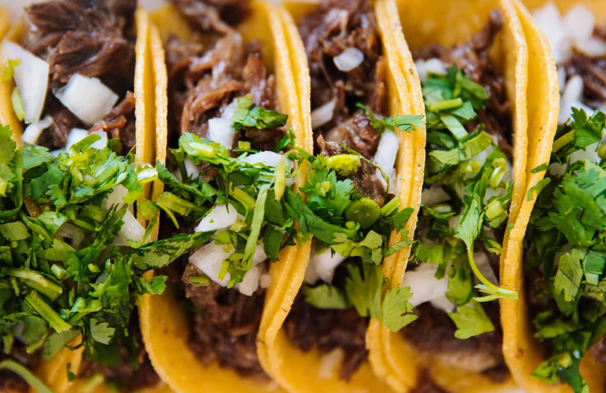 Beef tacos topped with cilantro and diced onion