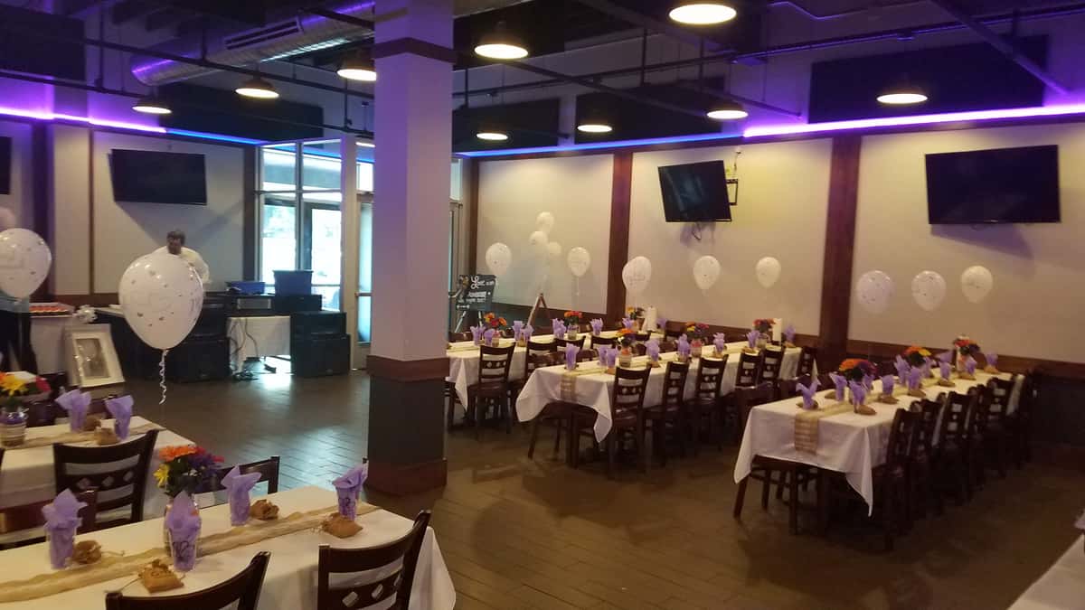 decorated party room with rows of long set tables
