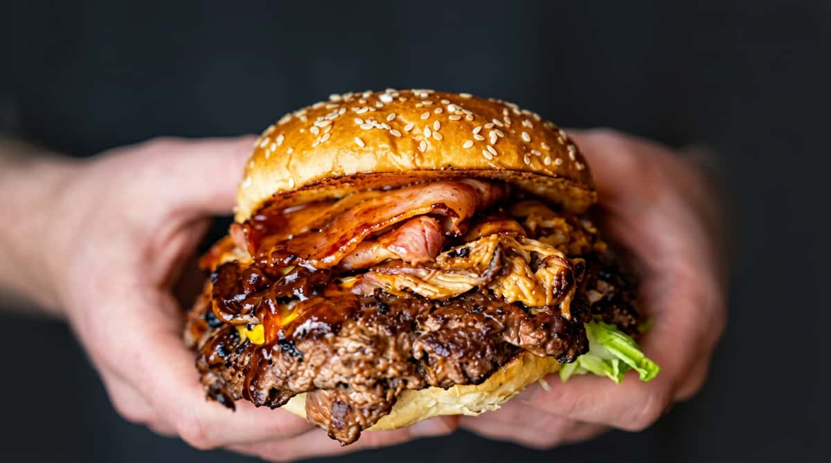 Burger Bros x Full Send South Wales collaboration burger with bacon, cheese, and BBQ sauce.