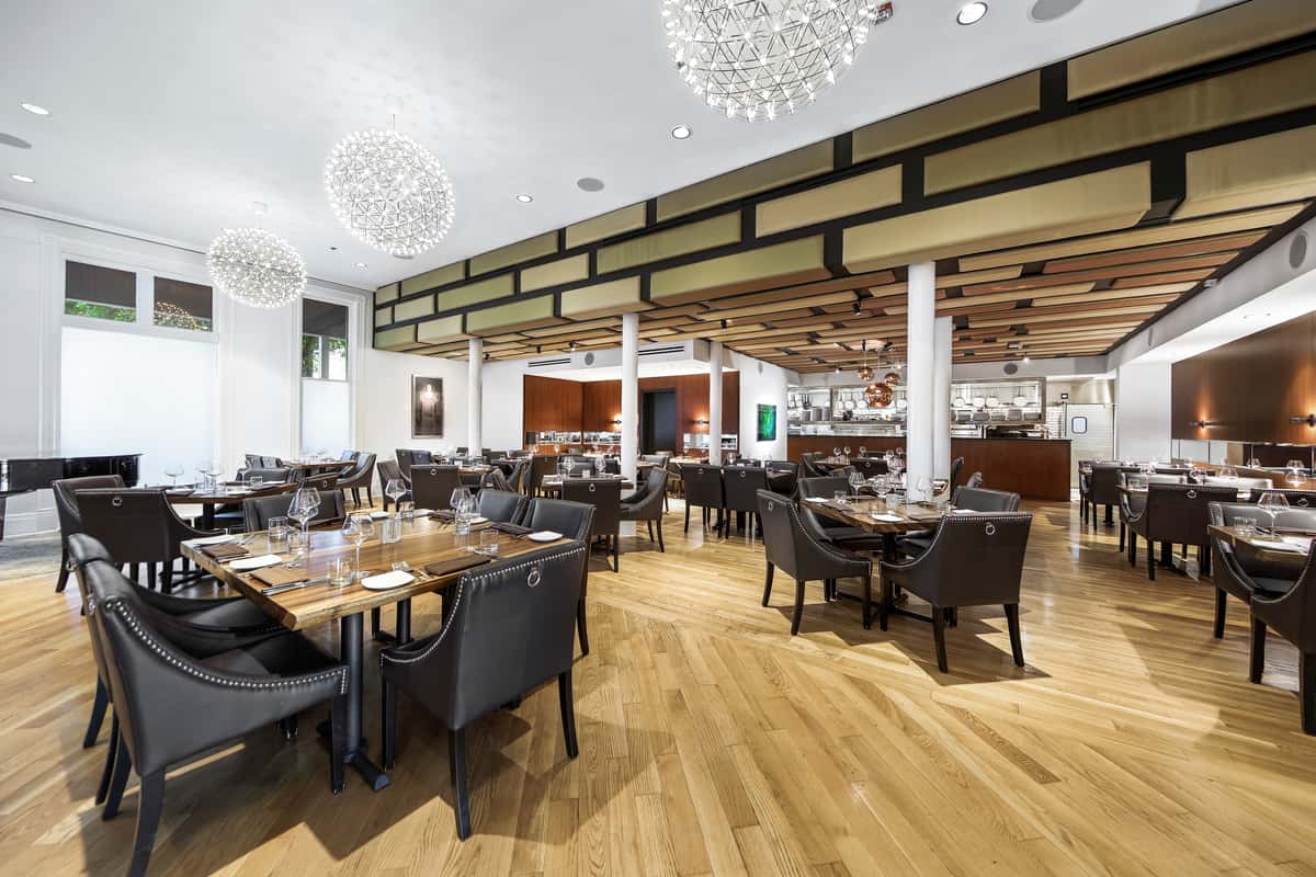 Silo Prime location's dining room with table, chairs, white tablecloths, and chandeliers