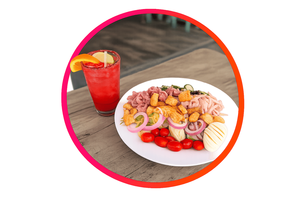 Fresh chef salad topped with sliced ham, turkey, hard-boiled egg, red onion, cherry tomatoes, and crunchy croutons, paired with a vibrant fruit cocktail.