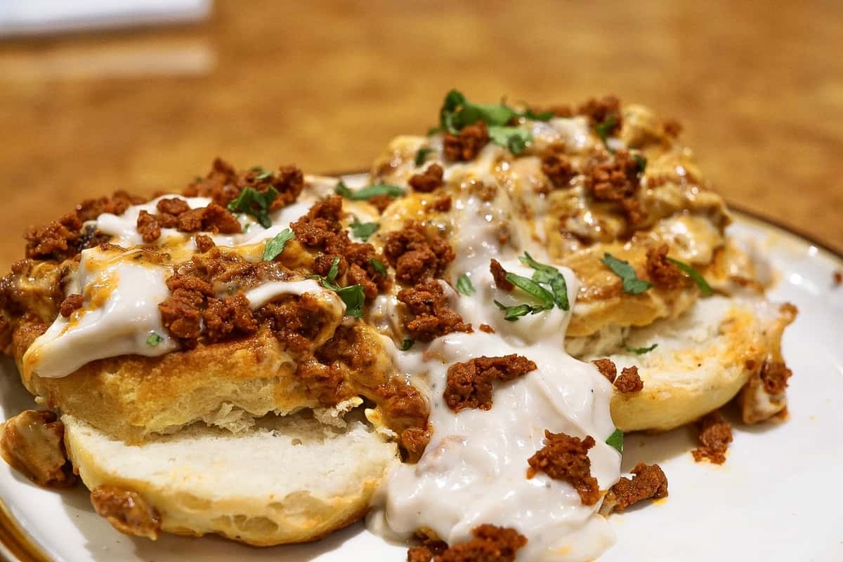 Flaky buttermilk biscuits topped with creamy white gravy, seasoned chorizo crumbles, melted cheese, and fresh cilantro for a savory Mexican breakfast twist.