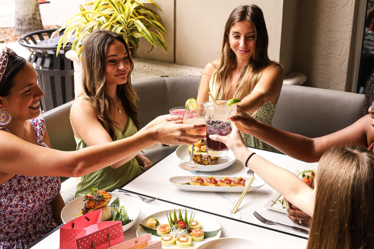 ladies toasting over table of menu items