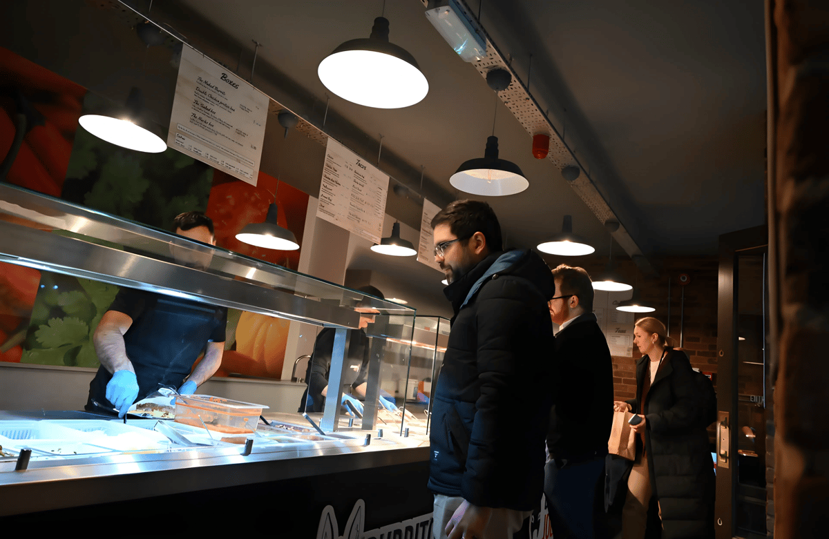 Guests selecting food from a buffet line inside a casual dining restaurant.