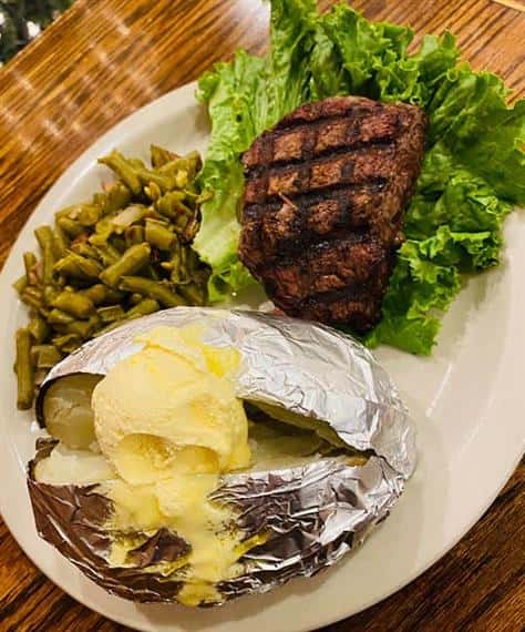 steak filet with a baked potato and green beans