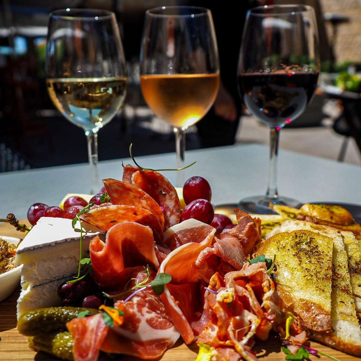 Charcuterie board with cured meats, artisan cheeses, and fresh fruit paired with red and white wine for a perfect shareable appetizer.