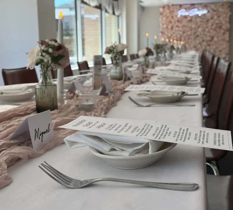 Elegant Mesero private dining setup with menus, florals, and place cards arranged along a long event table.