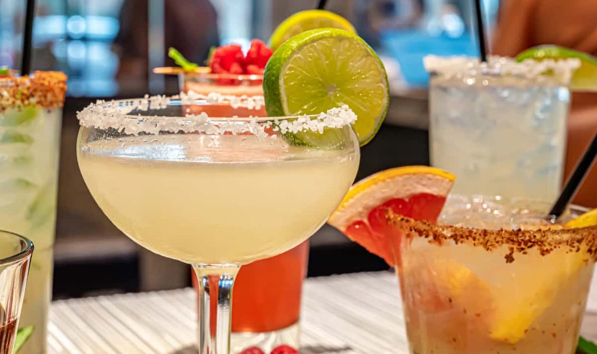 Mesero margaritas topped with lime and salt rim, showcased among vibrant holiday cocktails.