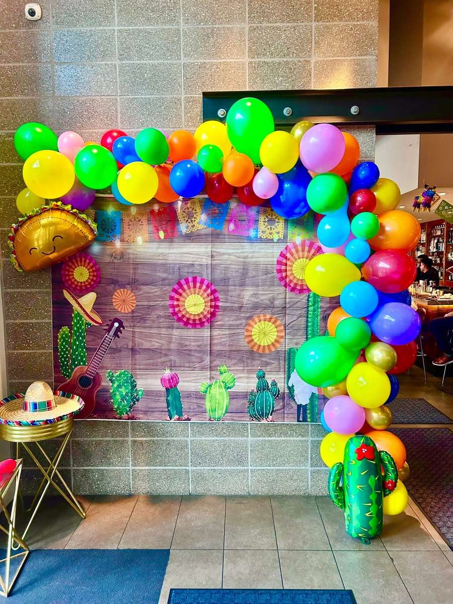 Colorful birthday balloon arch and Mexican-themed party decorations at Mesero.