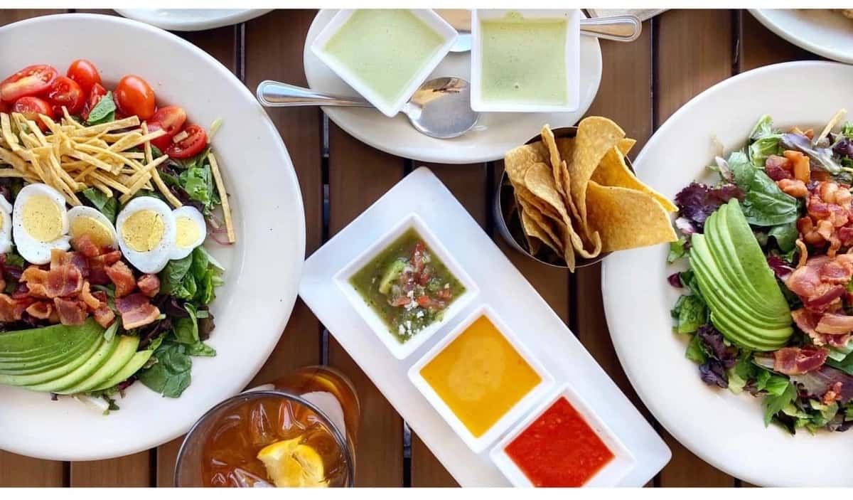 Mesero Hollywood Cobb salads served with tortilla chips, fresh salsas, and iced tea for a light and satisfying casual lunch.