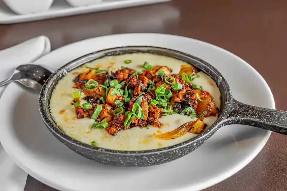 Skillet of creamy queso topped with chorizo and green onions served at Mesero.