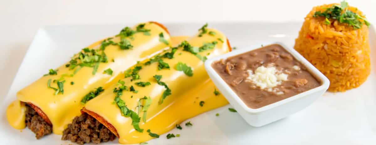 Mesero enchiladas topped with melted cheese and cilantro, served with refried beans and Mexican rice.