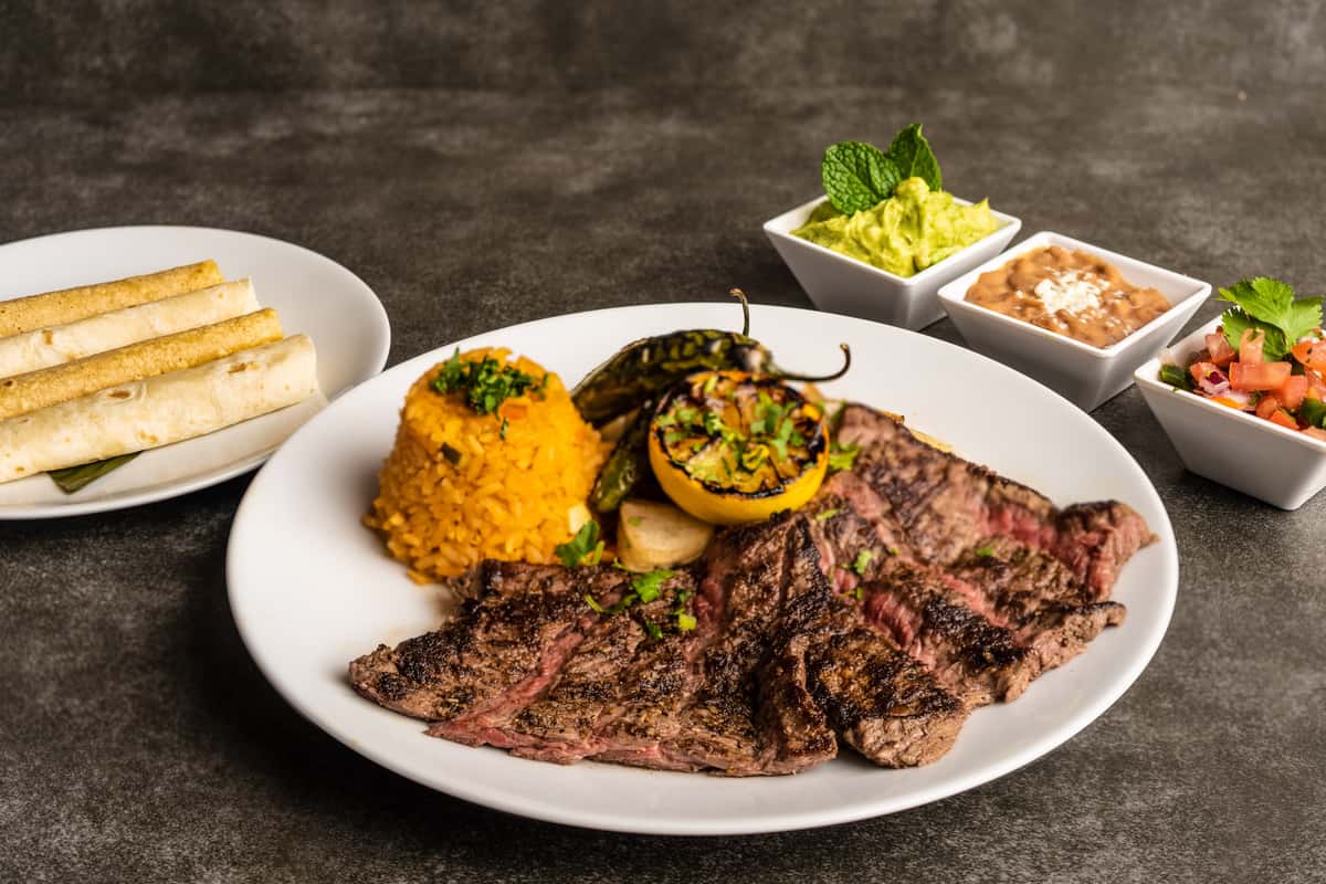 Mesero’s Fajitas with grilled steak, rice, and condiments.