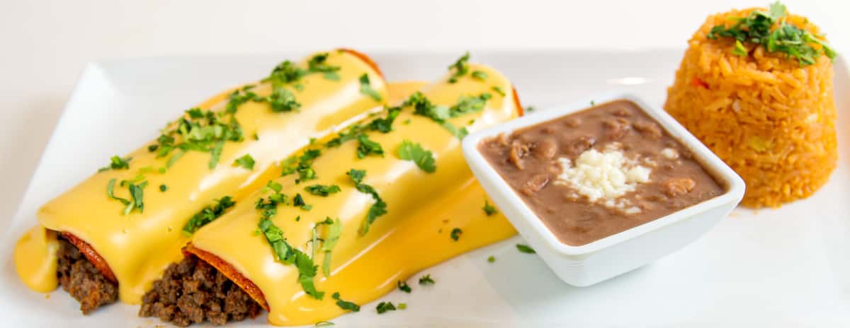 Mesero beef enchiladas topped with queso, served with refried beans and Mexican rice.
