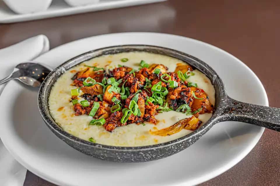 Skillet queso topped with chorizo and green onions served at Mesero.