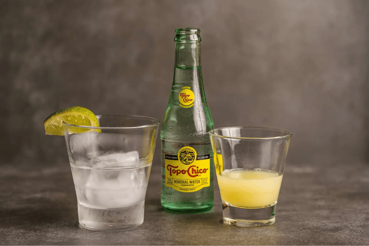 Mesero Topo Chico mineral water with lime and juice glasses ready for a refreshing cocktail mix.