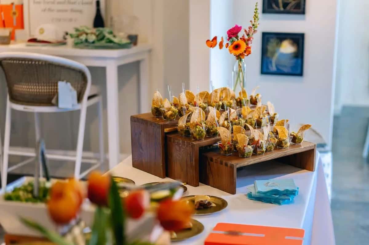 Mesero catering setup with appetizers and food displays for a group gathering.