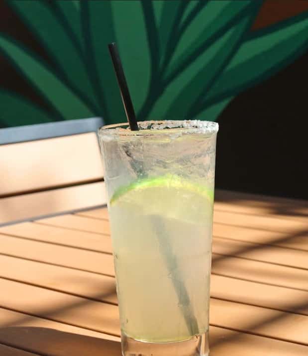 Mesero classic margarita with salted rim and lime slice served on a sunlit patio table.