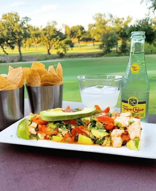 Fresh avocado ceviche with chips and Topo Chico at Mesero, served with a scenic outdoor view.