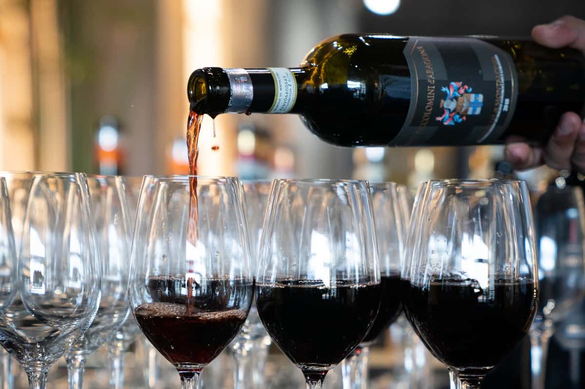 Red wine poured into rows of glasses at the Ciacci Piccolomini dinner at 360 Bistro Nashville