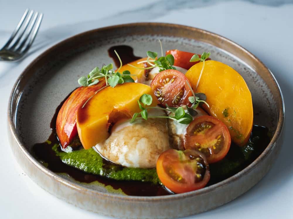 Heirloom & Burrata with heirloom tomatoes, summer peaches and burrata at 360 Bistro