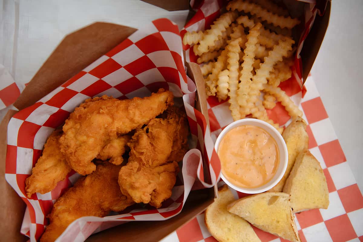 Hand breaded chicken tenders served with crinkle cut fries, cornbread, and creamy dipping sauce.