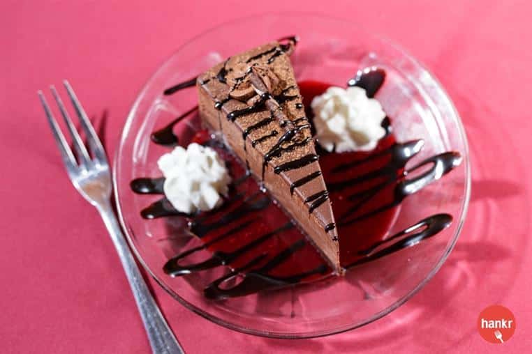 A piece of chocolate cake with chocolate syrup