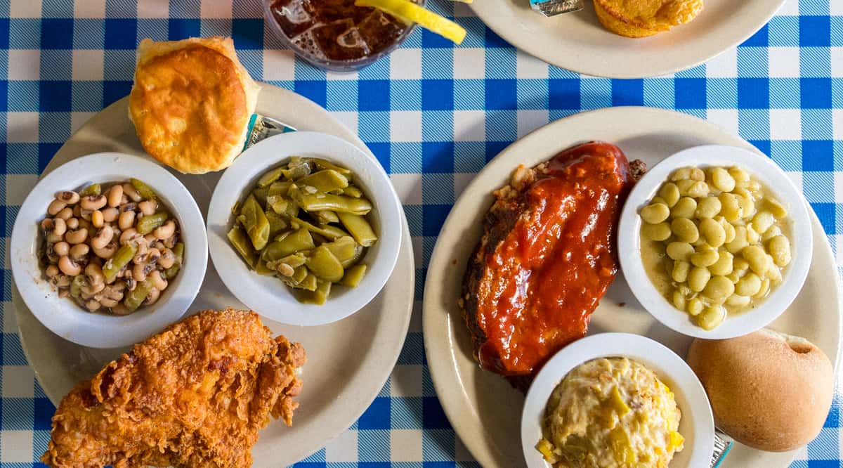 Southern comfort foods, fried chicken, meatloaf and sides on a table