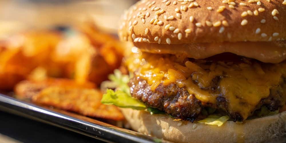 Cheesy burger served with seasoned fries