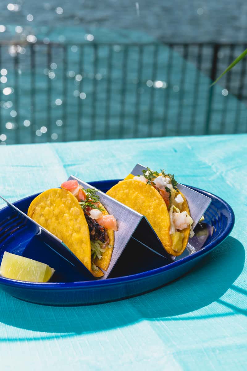 Fresh seafood tacos served on a waterfront patio table with bay views and coastal outdoor dining ambiance