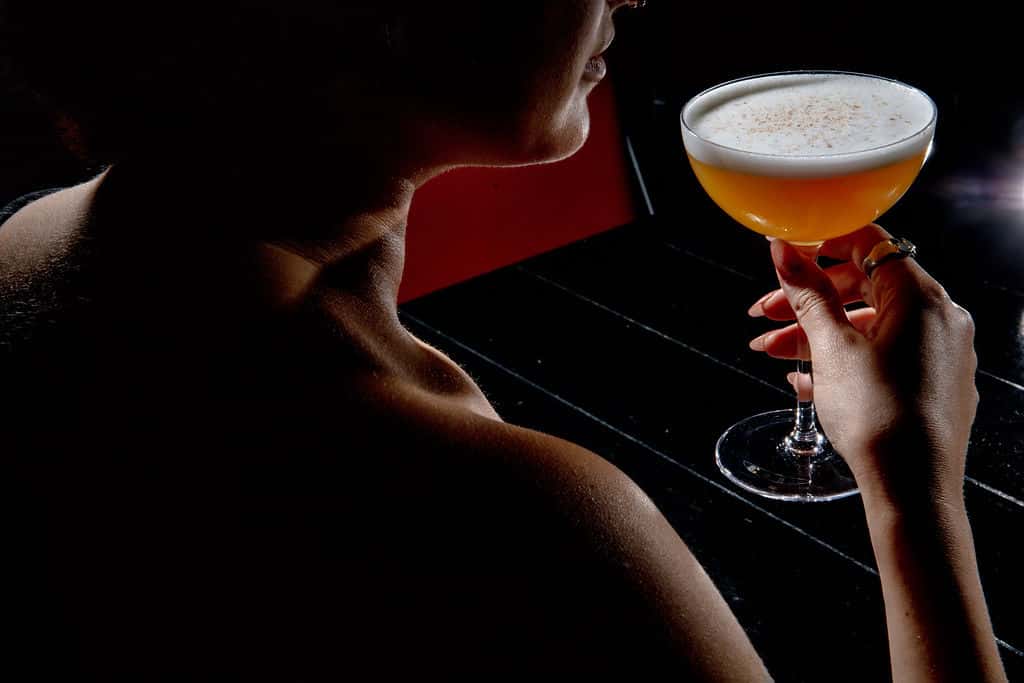 Guest enjoying a handcrafted cocktail in an intimate Michelin dining setting, illustrating refined beverage service and sommelier etiquette in Miami.