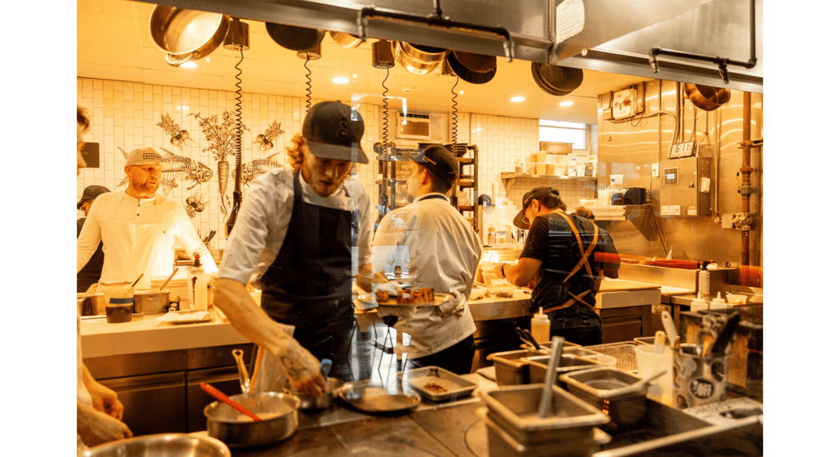 Skilled chefs preparing dishes in an open kitchen, demonstrating the expertise and precision behind Michelin-star cuisine.