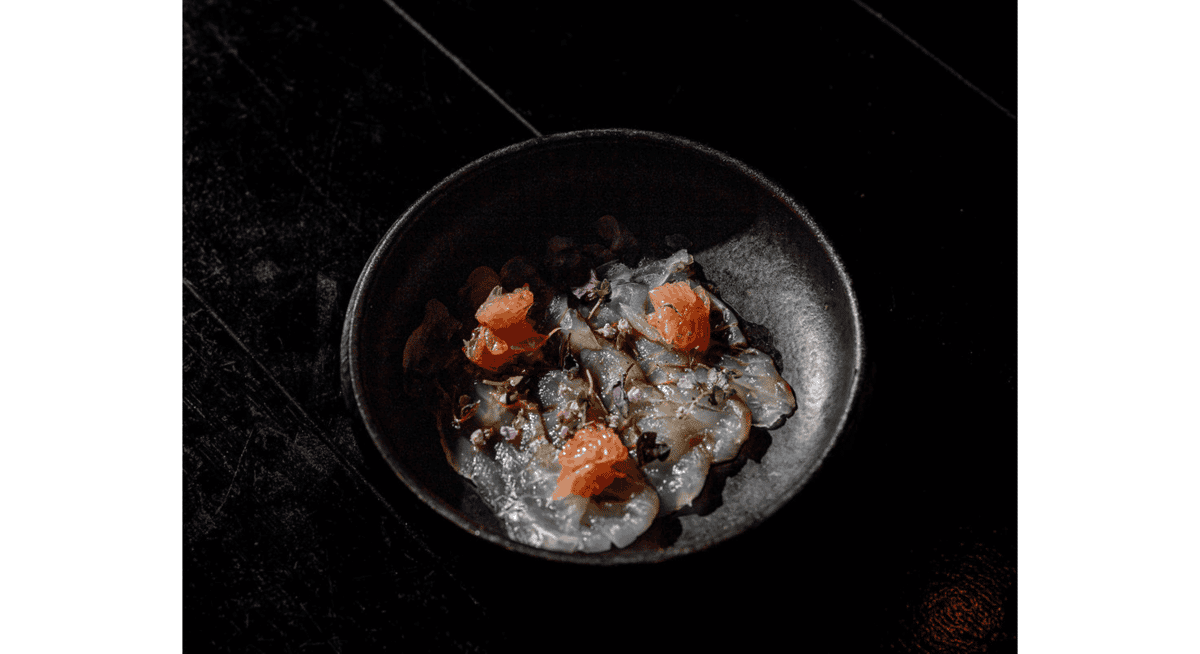Delicately plated seafood course with refined presentation and precise garnishes, showcasing the elevated standards of Michelin-star dining.