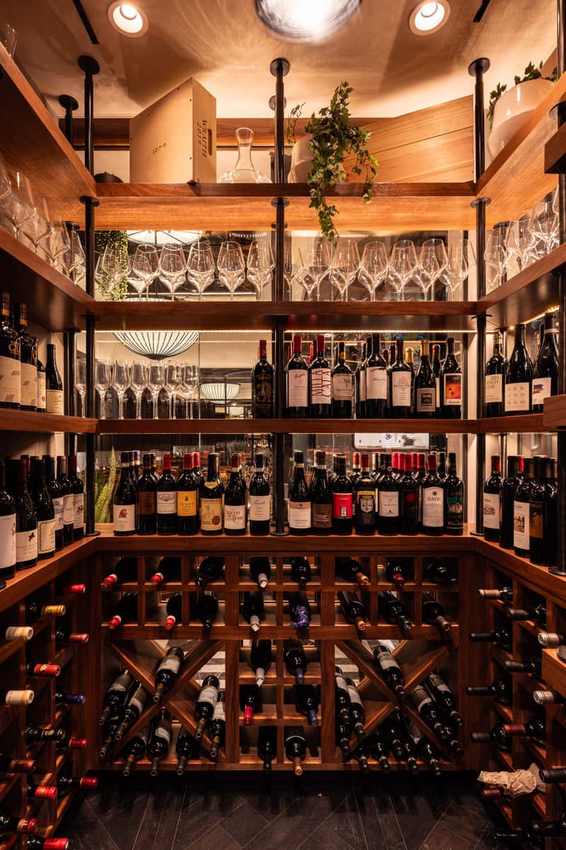Luxury wine cellar display with bottles, wine glasses, and warm wood shelving