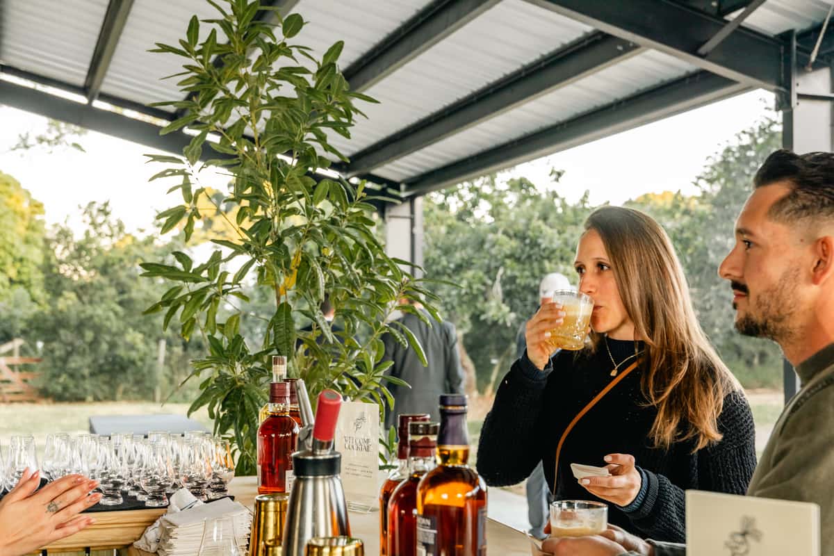 Outdoor cocktail tasting experience at a unique Miami dining venue with guests enjoying handcrafted drinks in a garden setting.
